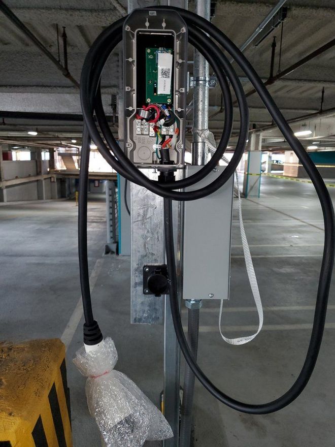 A black cord is attached to a pole in a parking garage