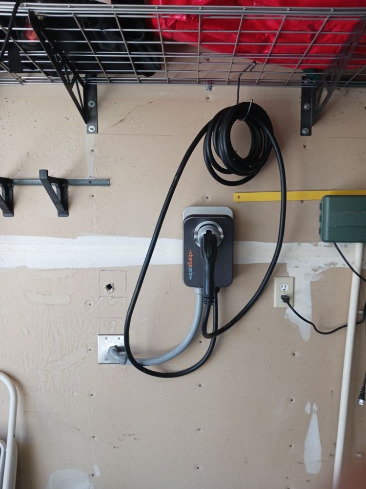 A charger is plugged into a wall in a garage