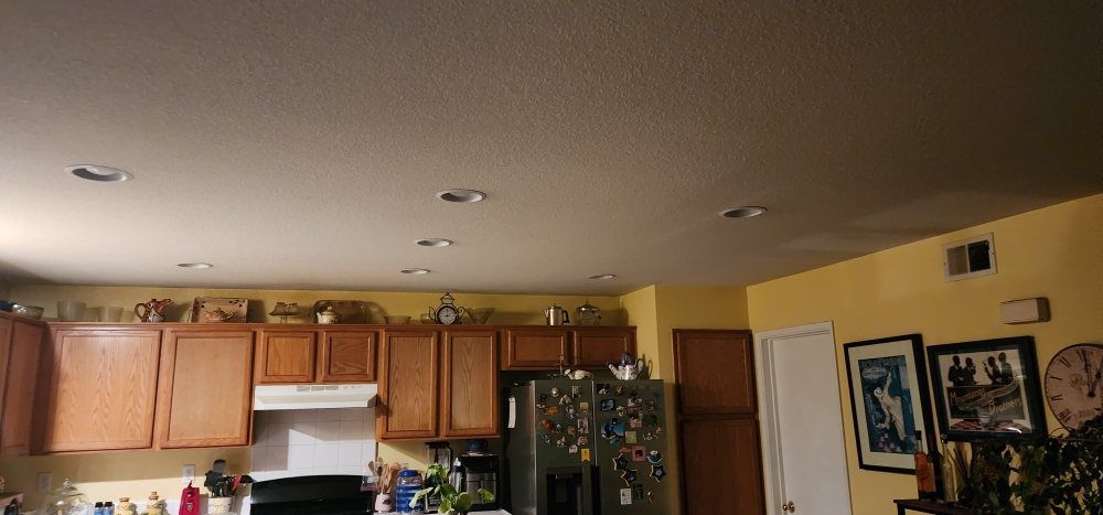 A kitchen with wooden cabinets , a refrigerator and a stove.