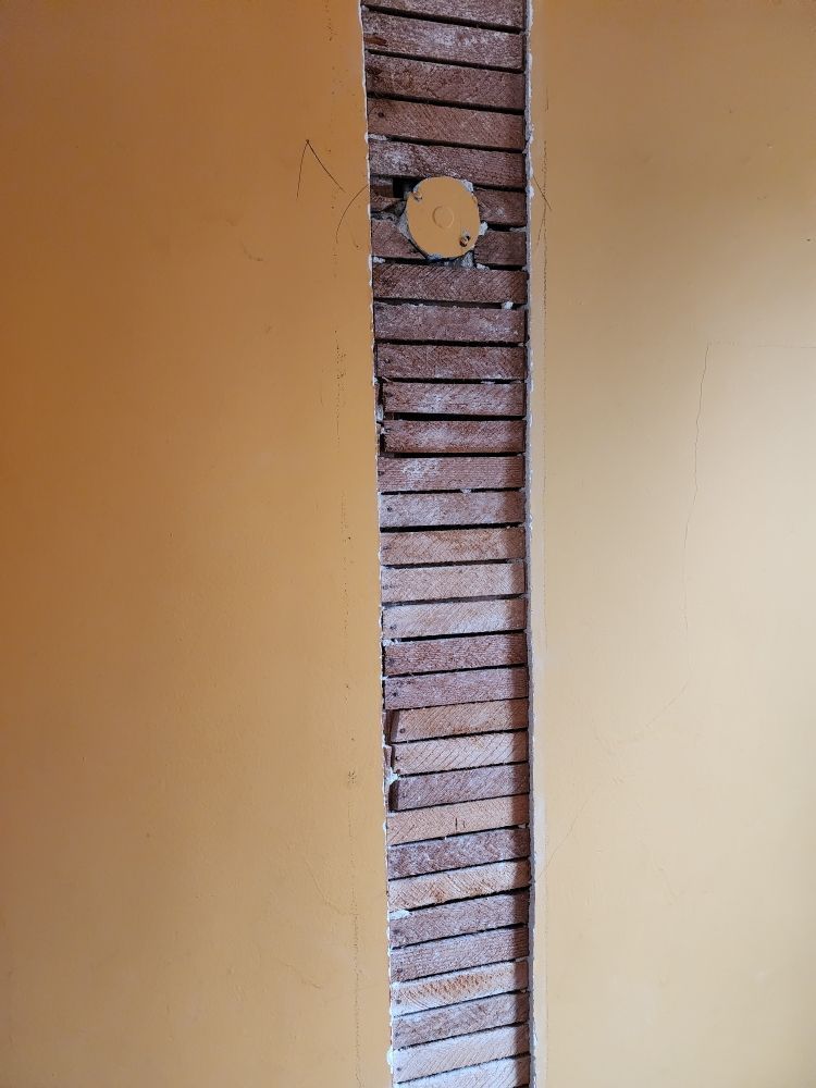A brick wall with a hole in the middle of it.