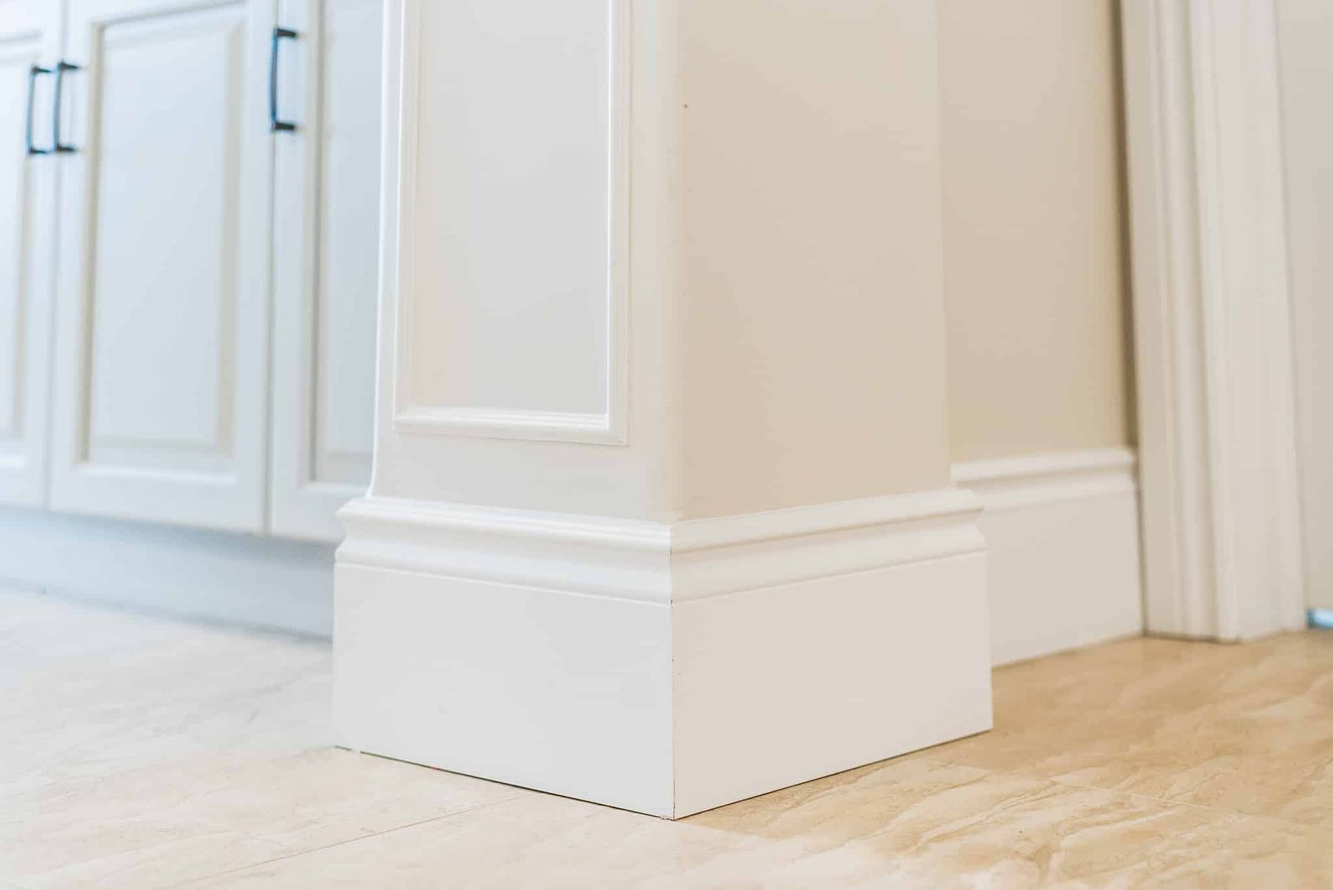 A close up of a white molding on a wall in a kitchen.