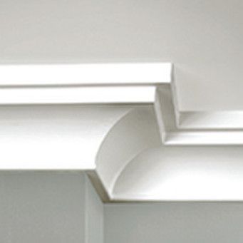 A close up of a white cornice on a white wall.