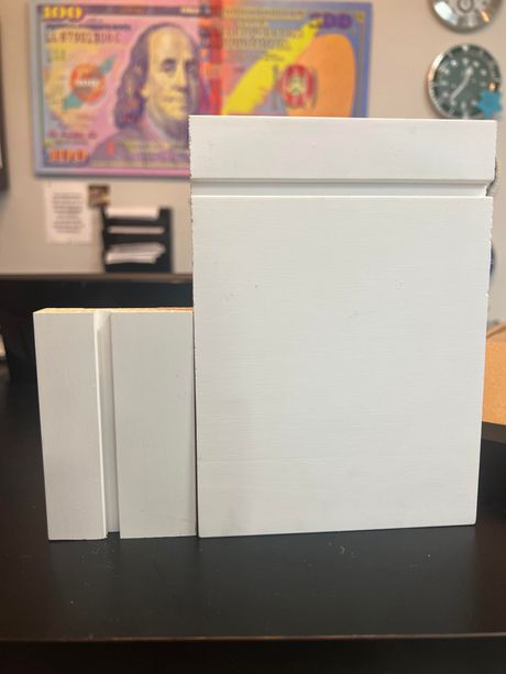 Three white boxes are sitting on a table in front of a painting of franklin d. roosevelt