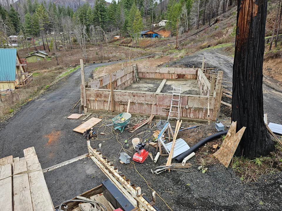 A wooden structure is being built on the side of a road next to a tree.
