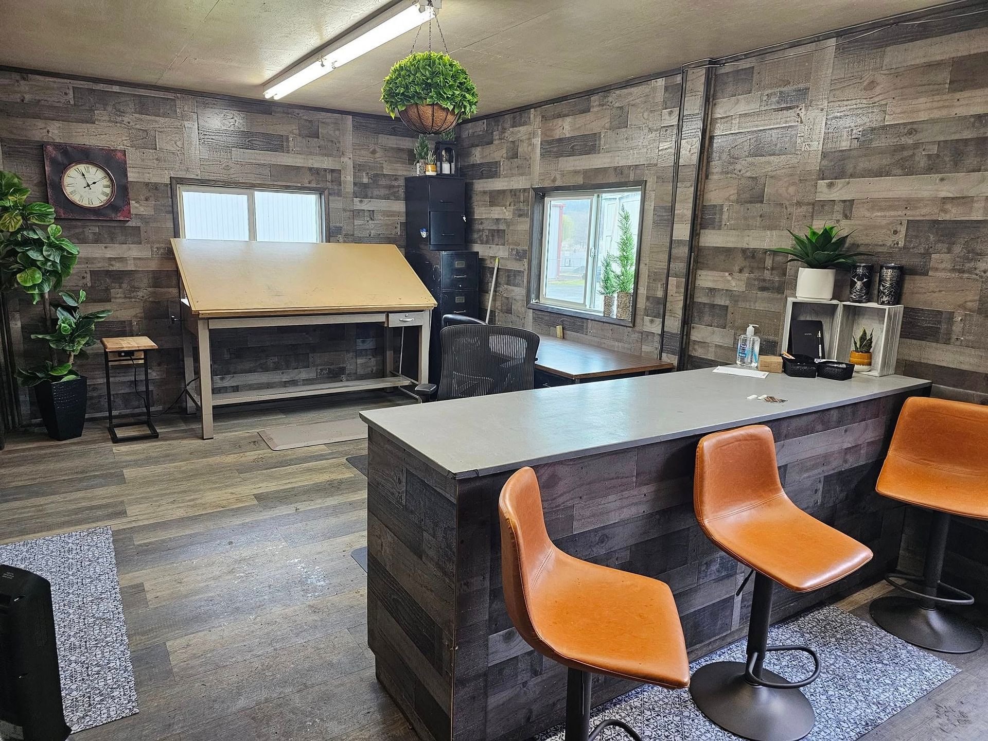 A room with a table , chairs , and a clock on the wall.