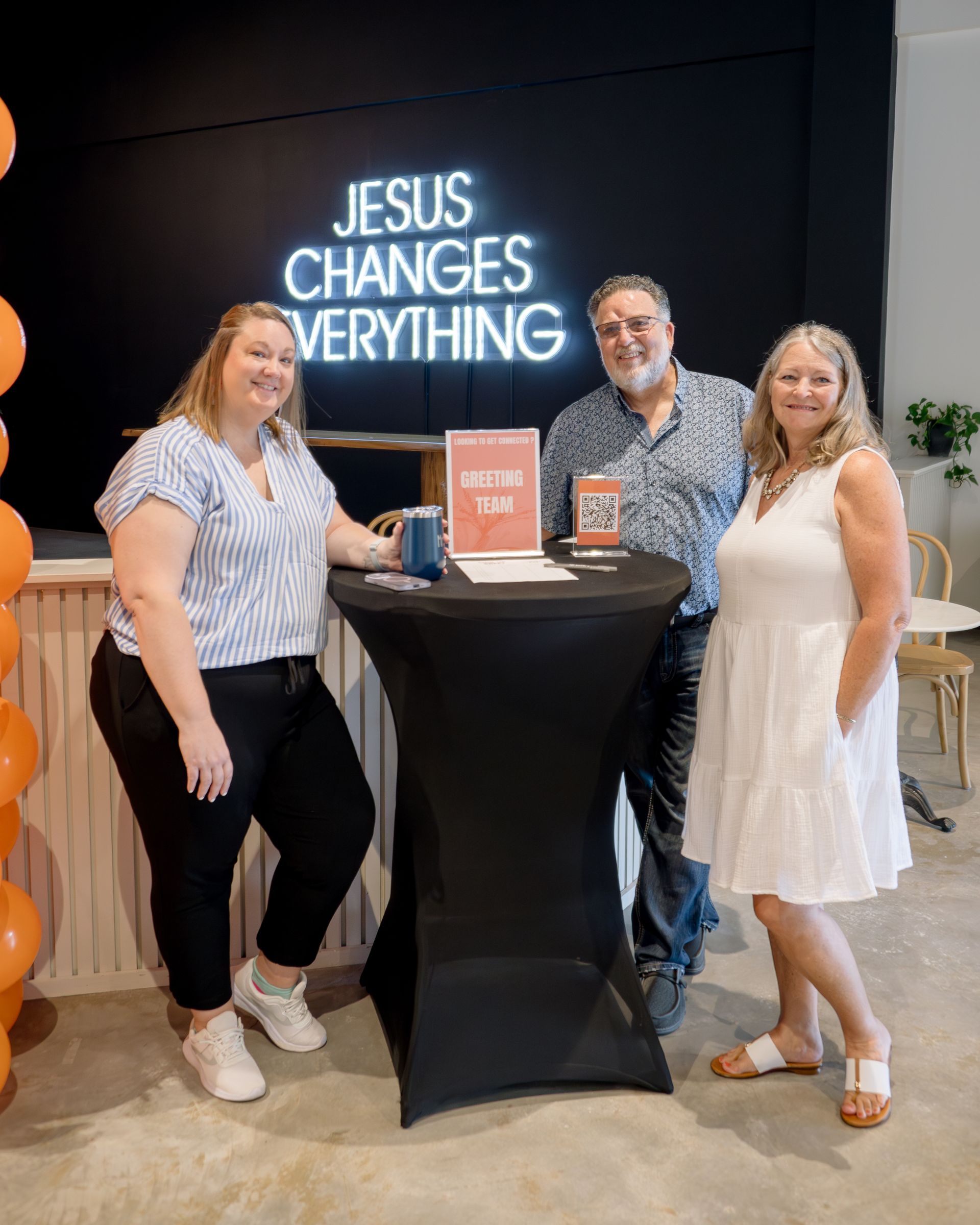 Three people stand at a table with a