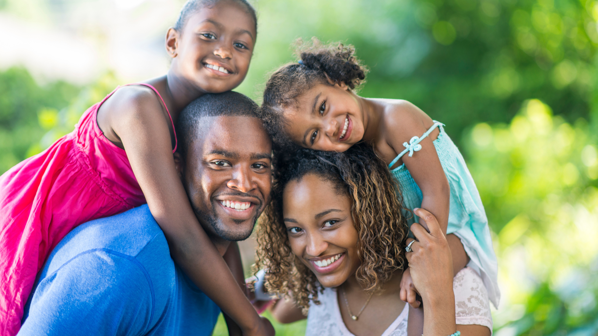 A family is posing for a picture together in a park.