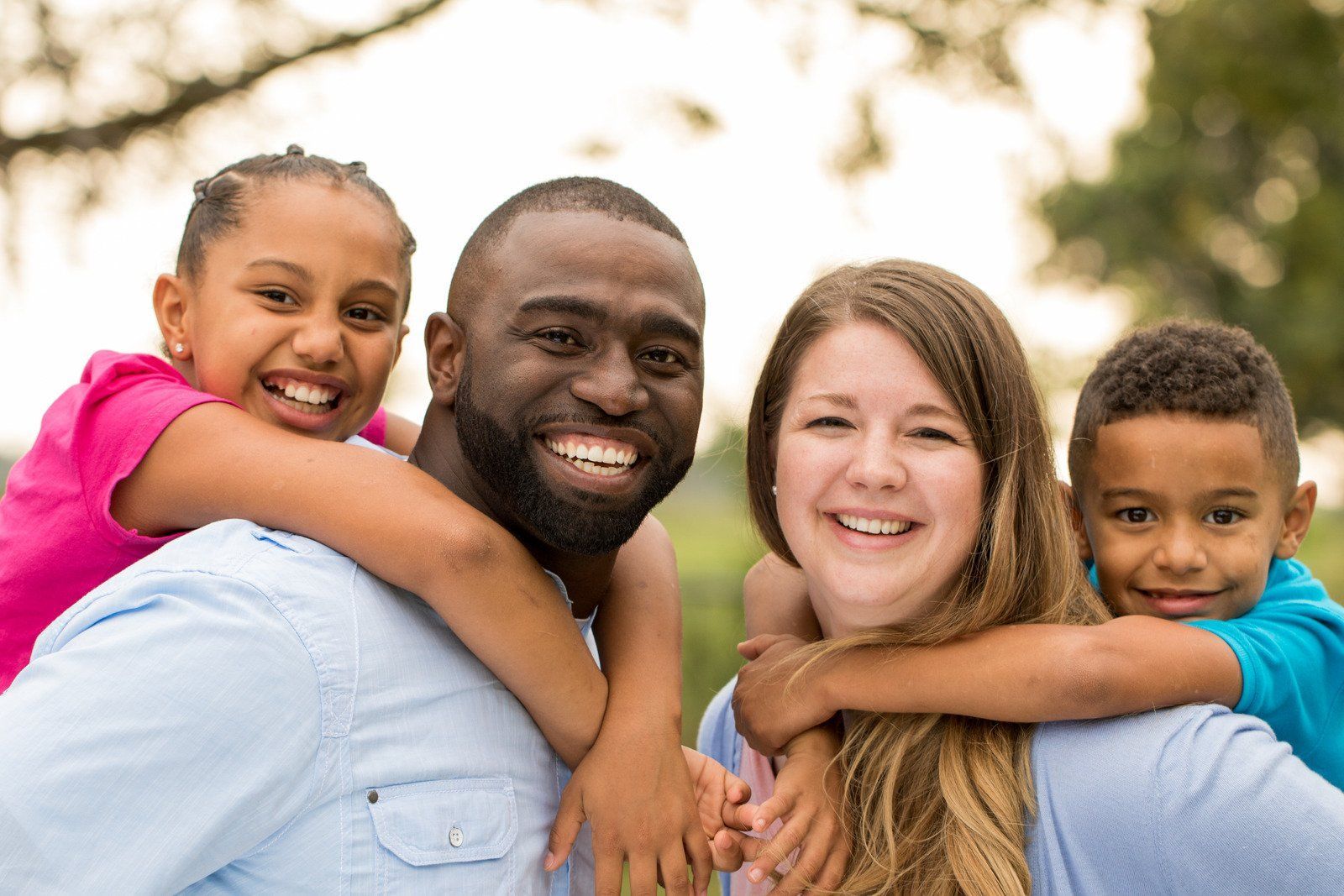 A family is posing for a picture together in a park.