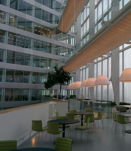 A large building with lots of windows and tables and chairs