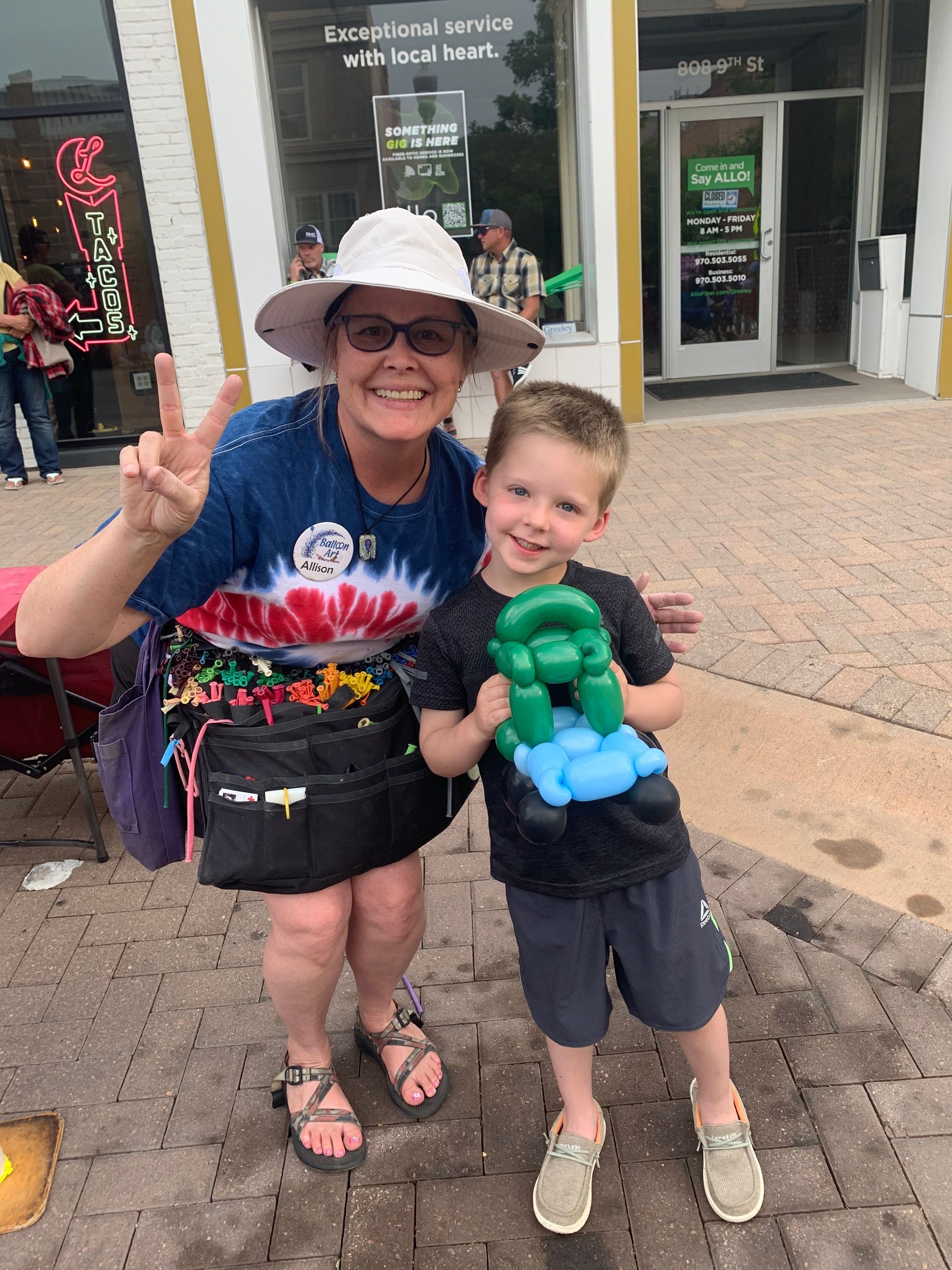 Allison - Professional Balloon Artist is standing next to one of her creations.