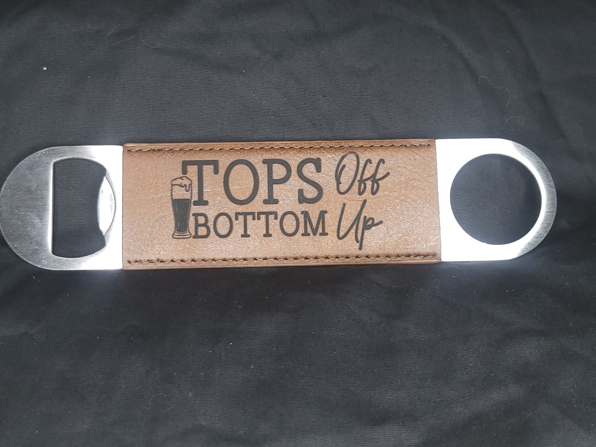 A bottle opener with the words tops off bottom up on it