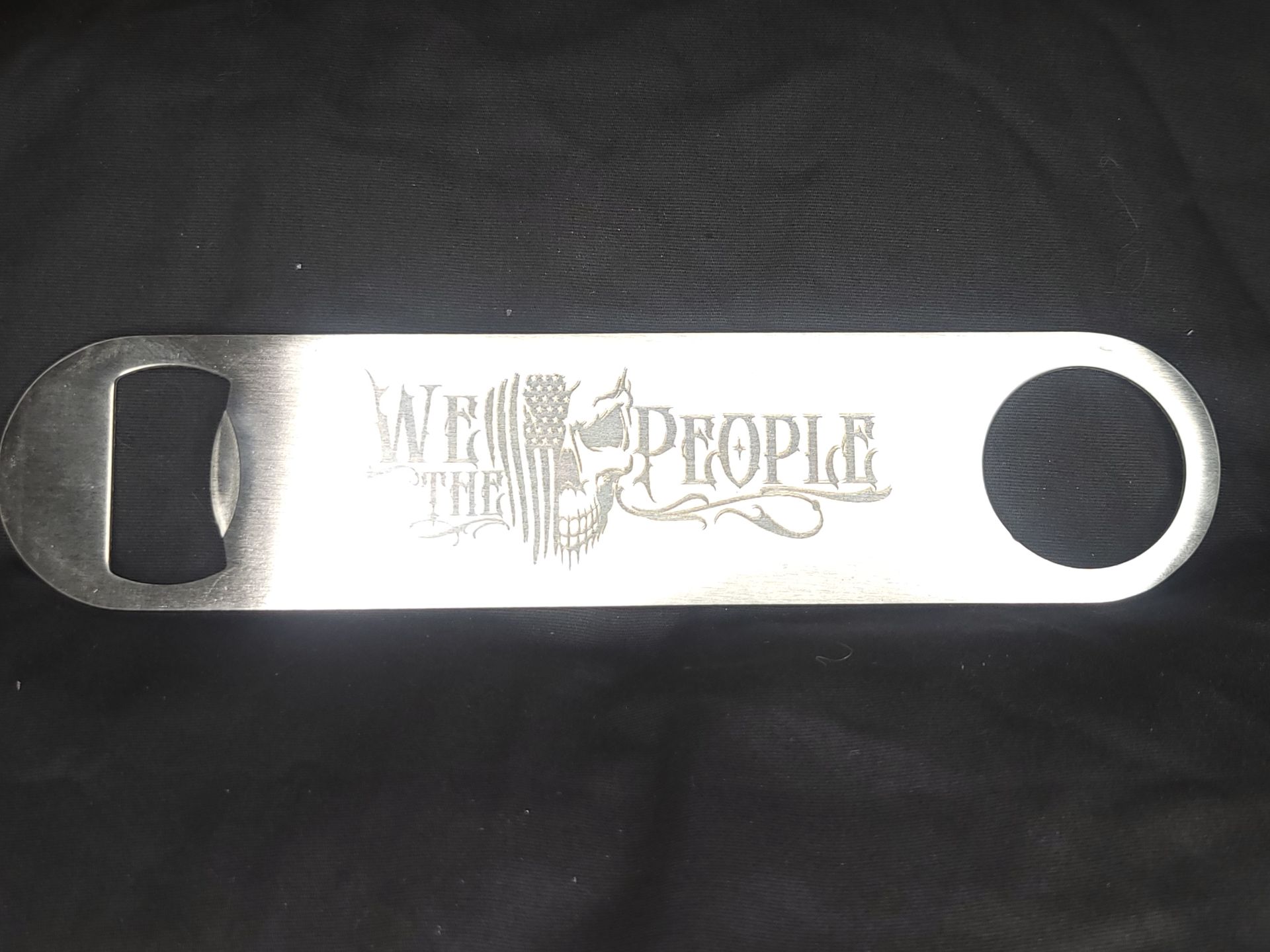 A stainless steel bottle opener with the words