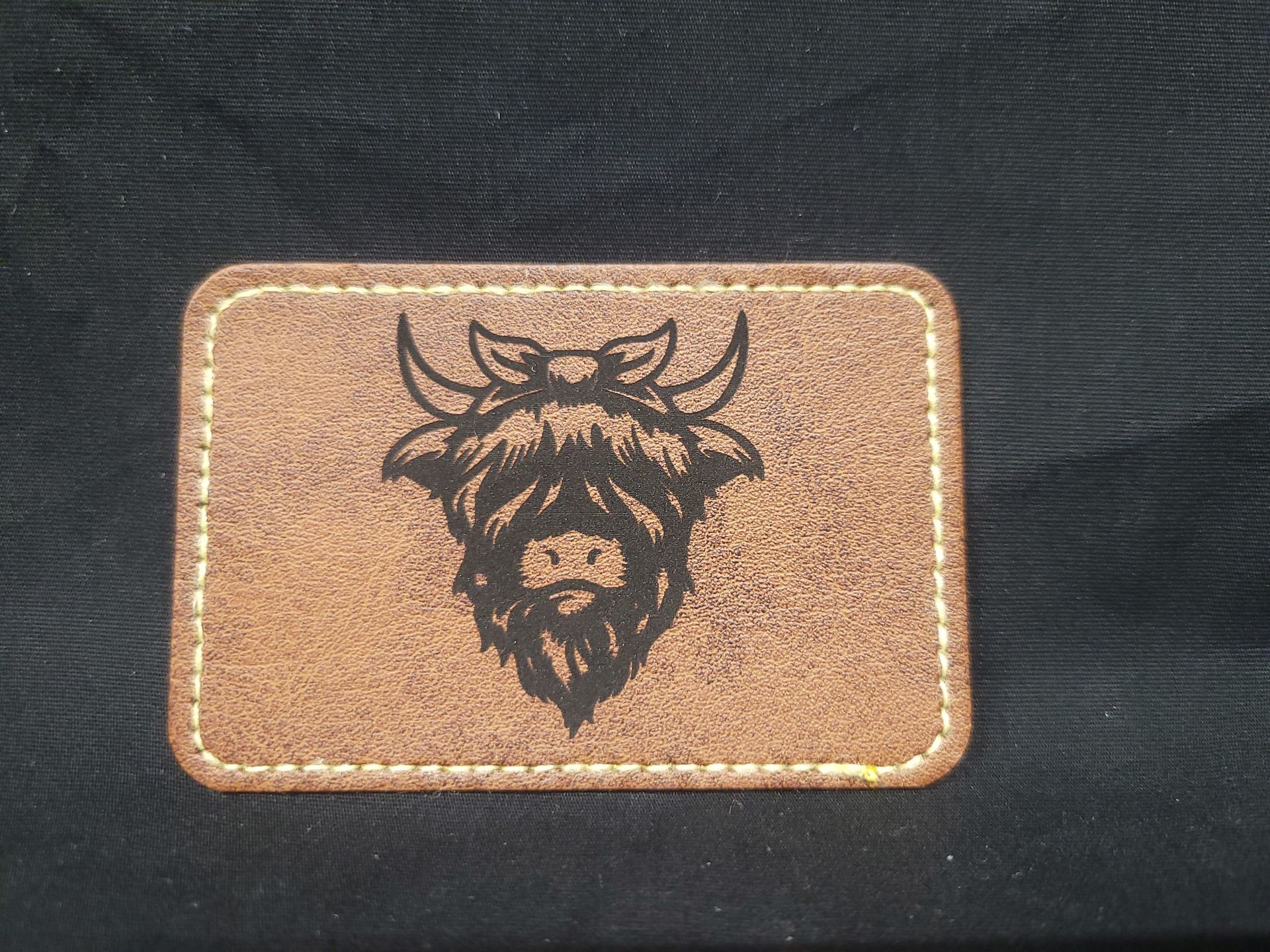 A brown leather patch with a picture of a bull on it