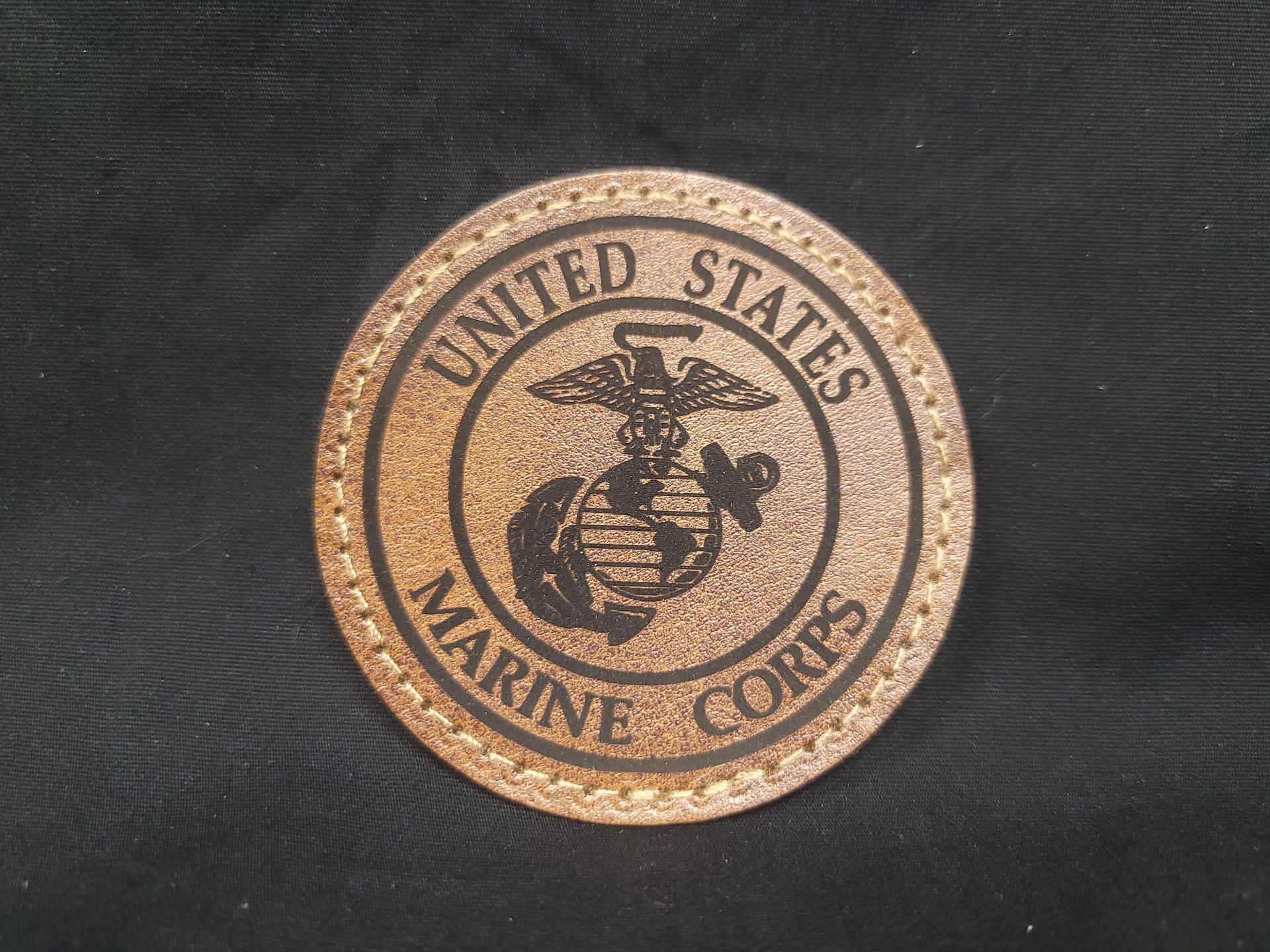 A united states marine corps coin on a black background