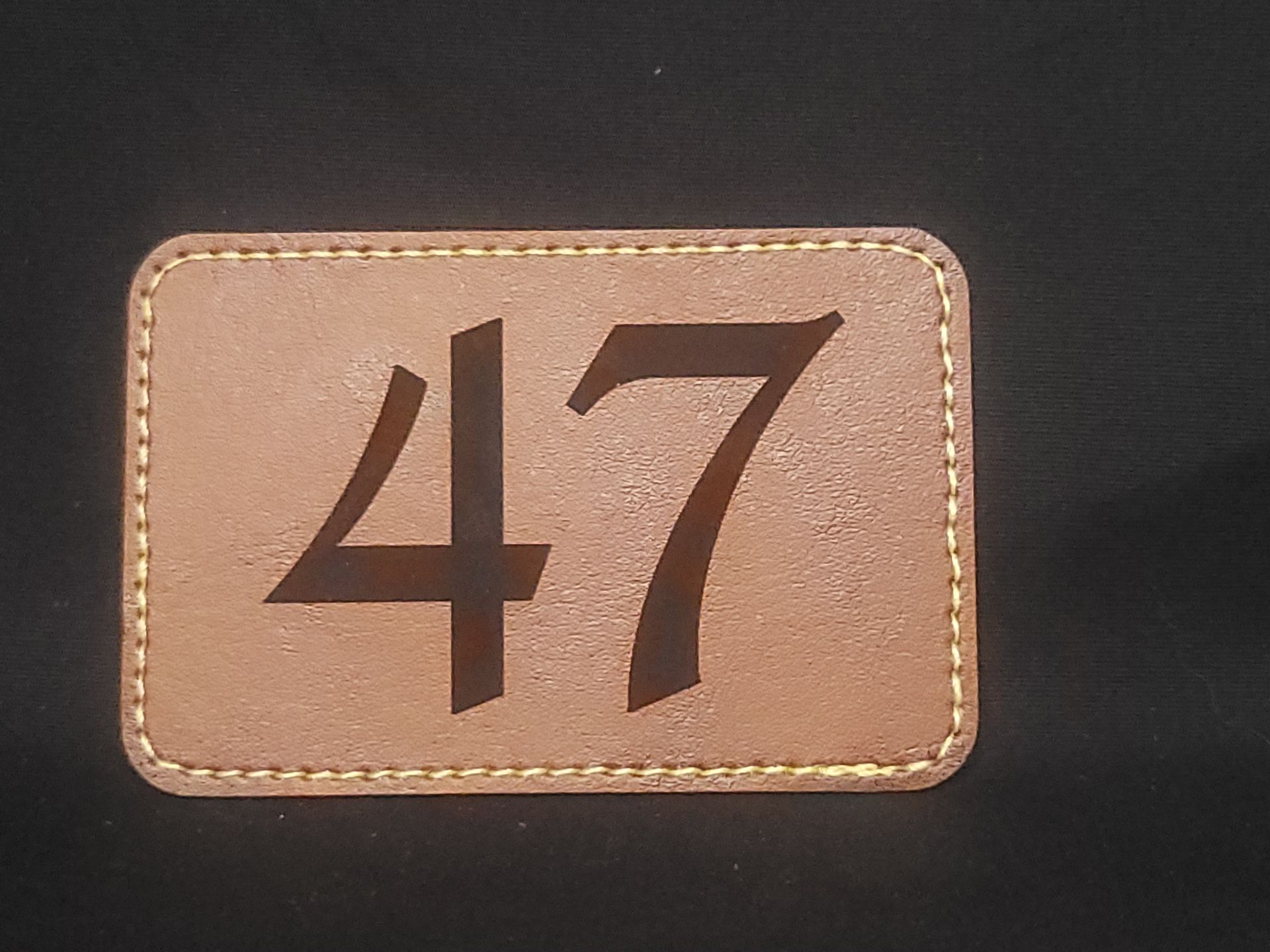 A brown leather patch with the number 47 on it