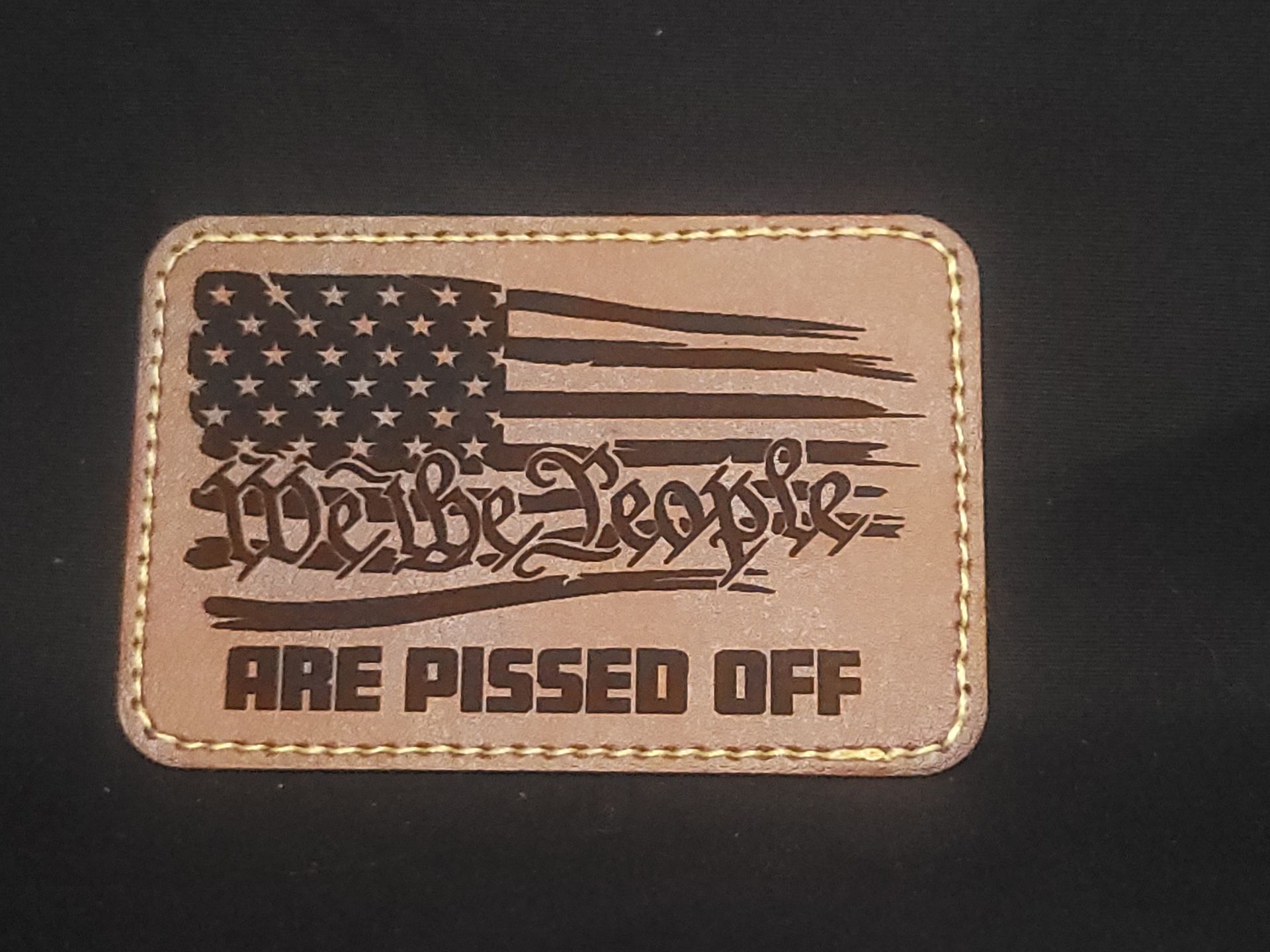 A patch that says ' are pissed off ' on it