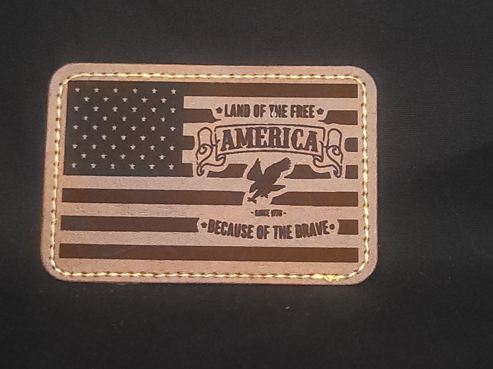 A patch that says land of the free america because of the brave