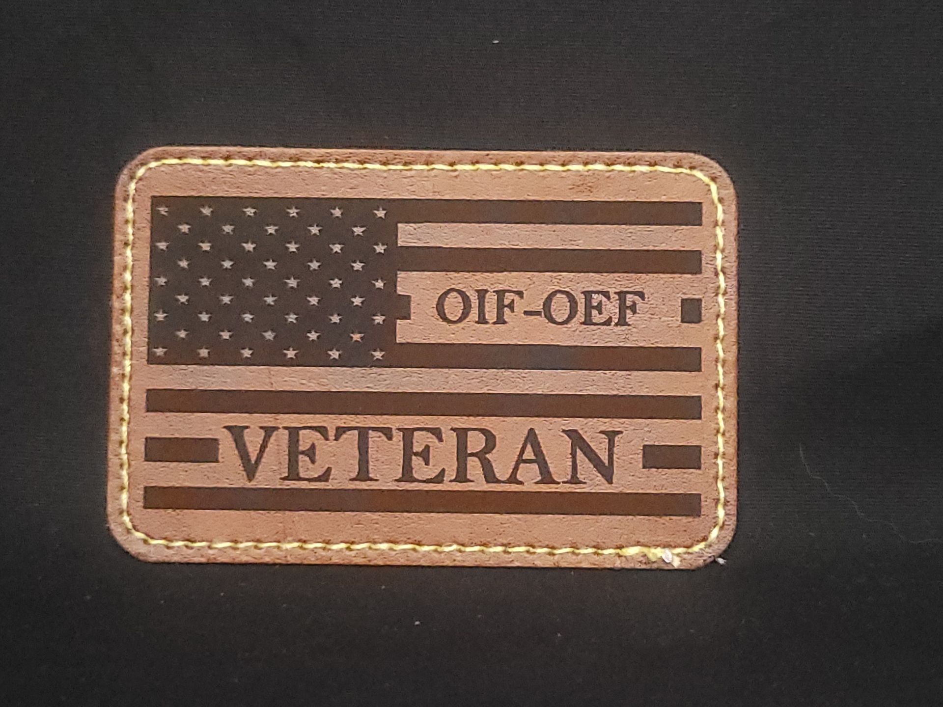 A brown leather patch that says veteran on it