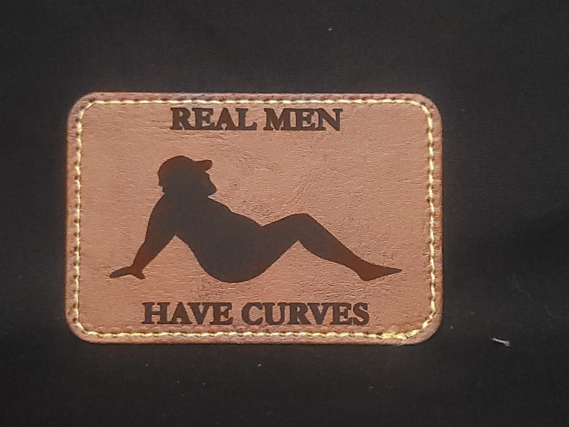 A brown patch that says real men have curves