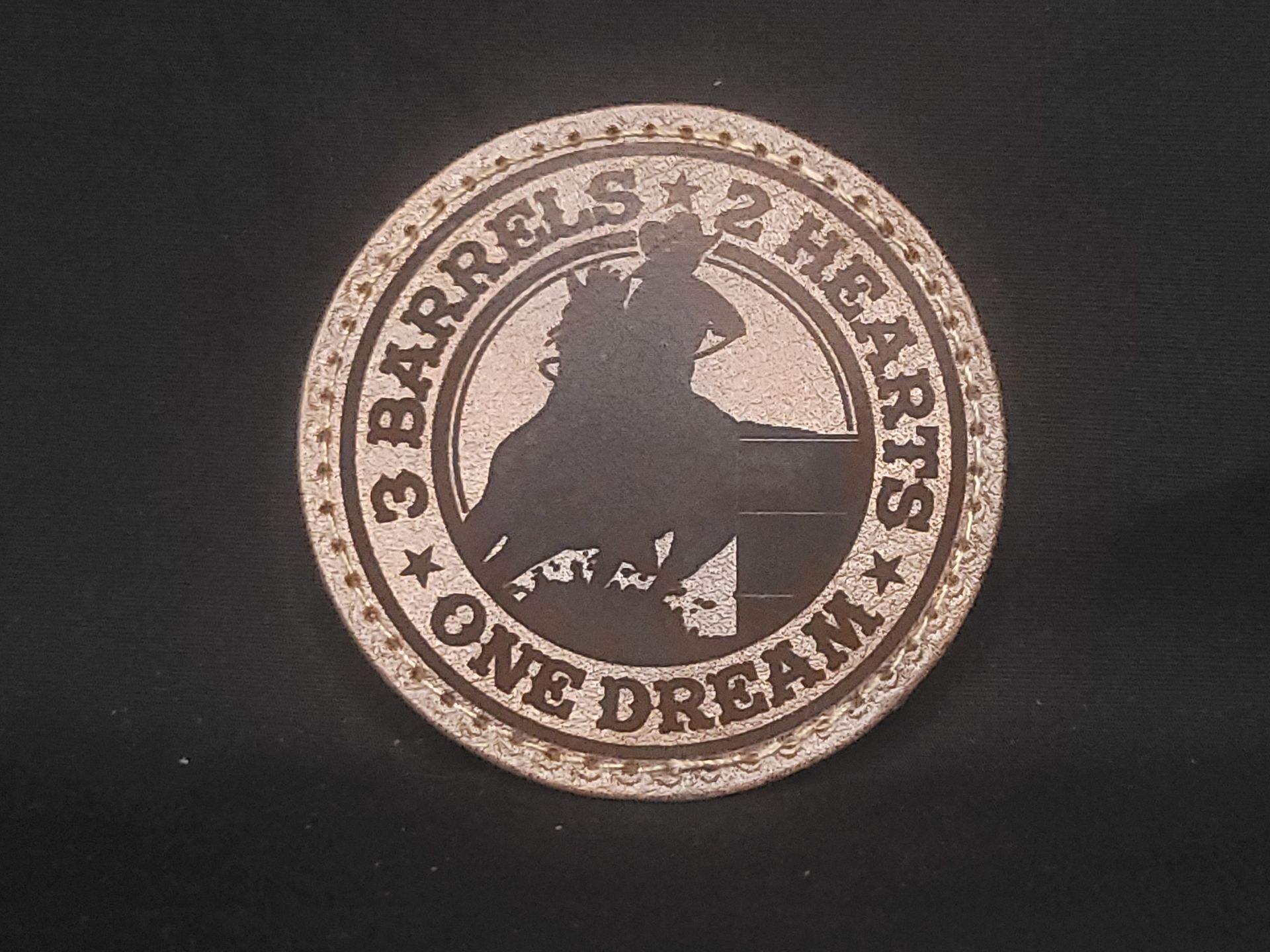 A coin that says 3 barrels 2 hearts one dream