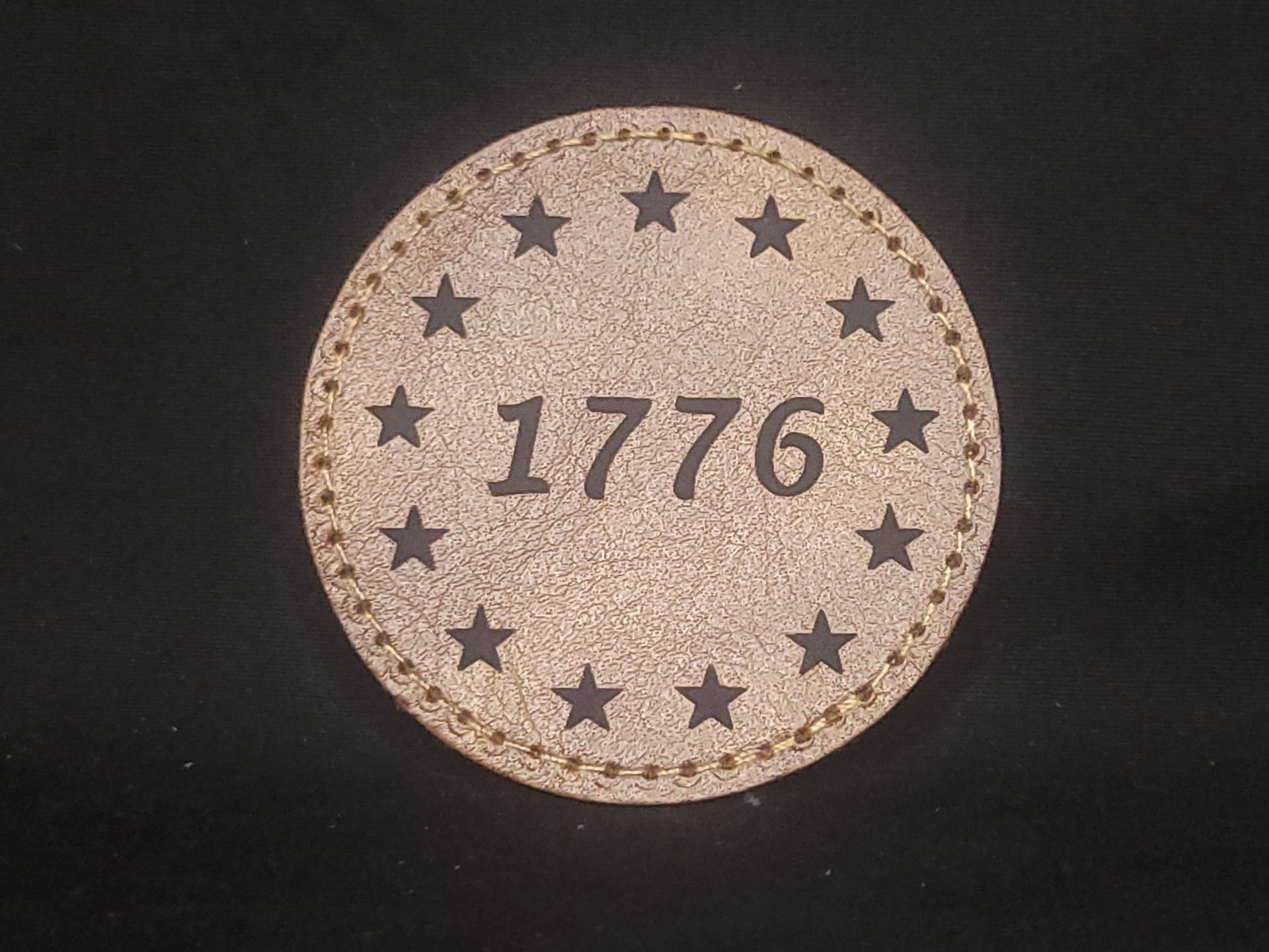A cork coaster with the year 1776 on it