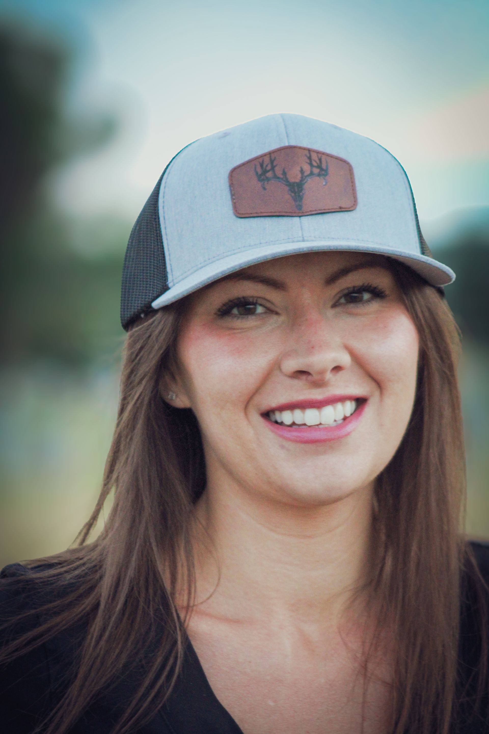 A close up of a woman wearing a hat and smiling.