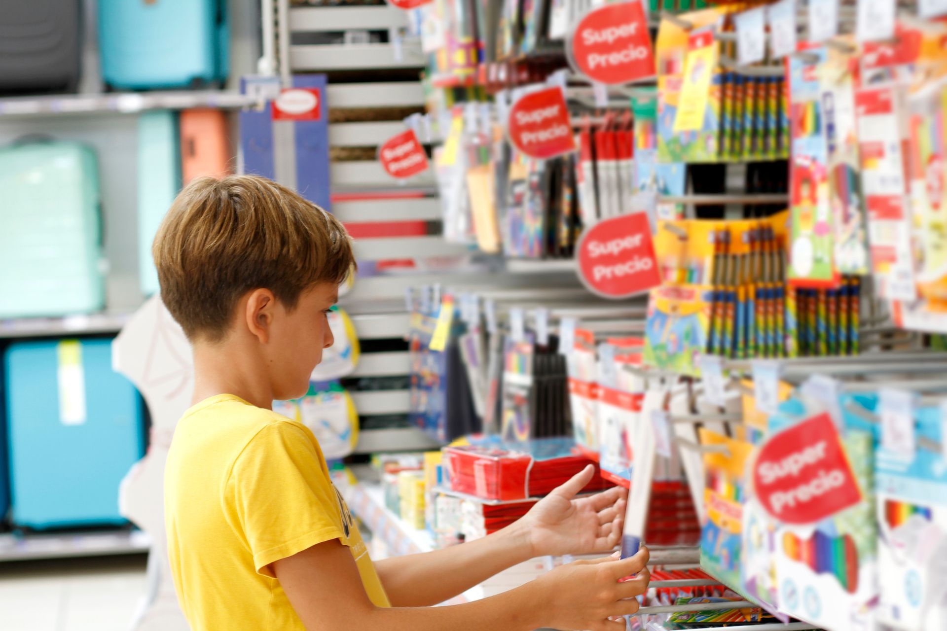 Un ragazzino sta acquistando materiale scolastico in un negozio.