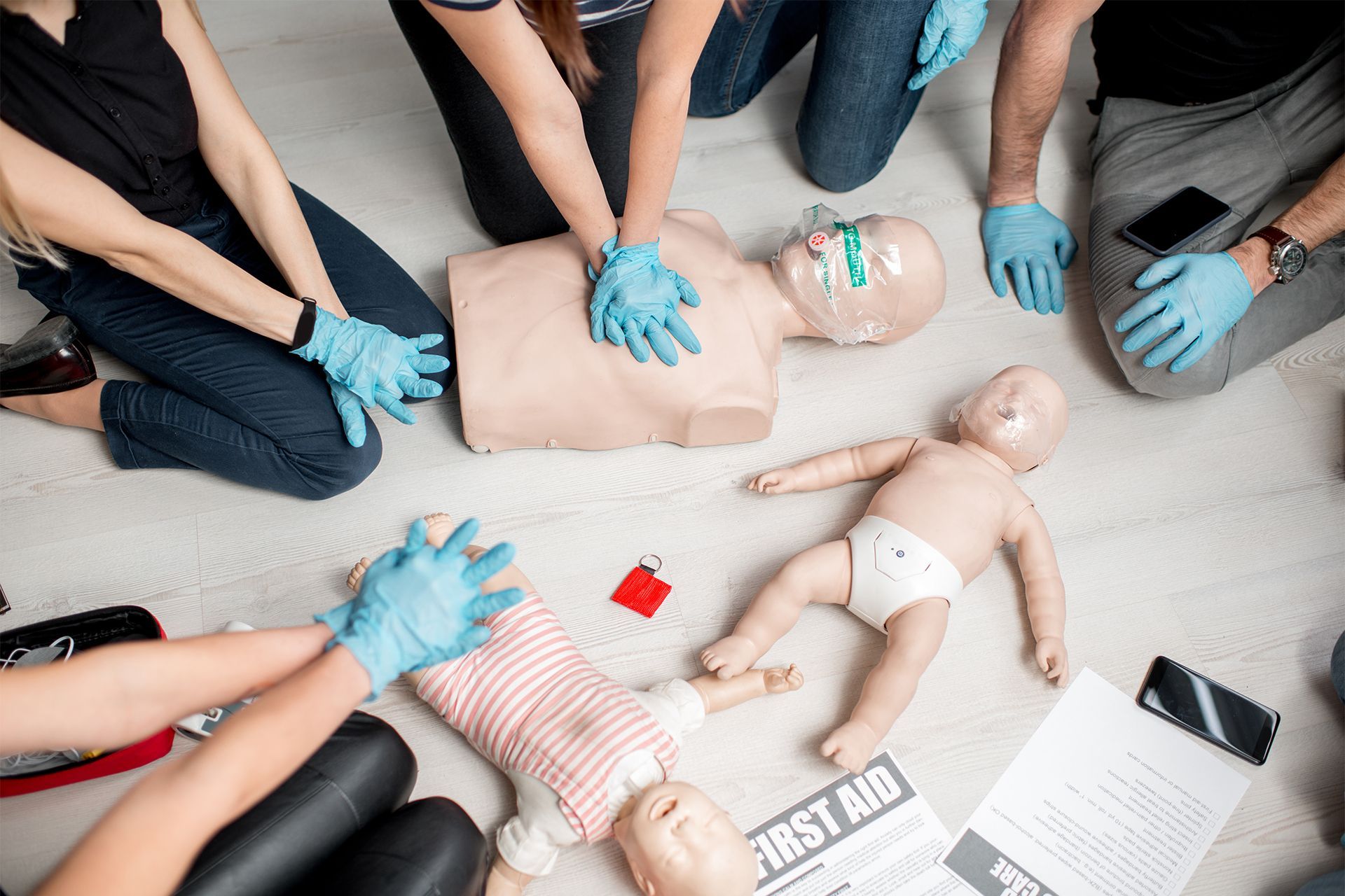 People practice CPR on mannequins during a first aid training course.