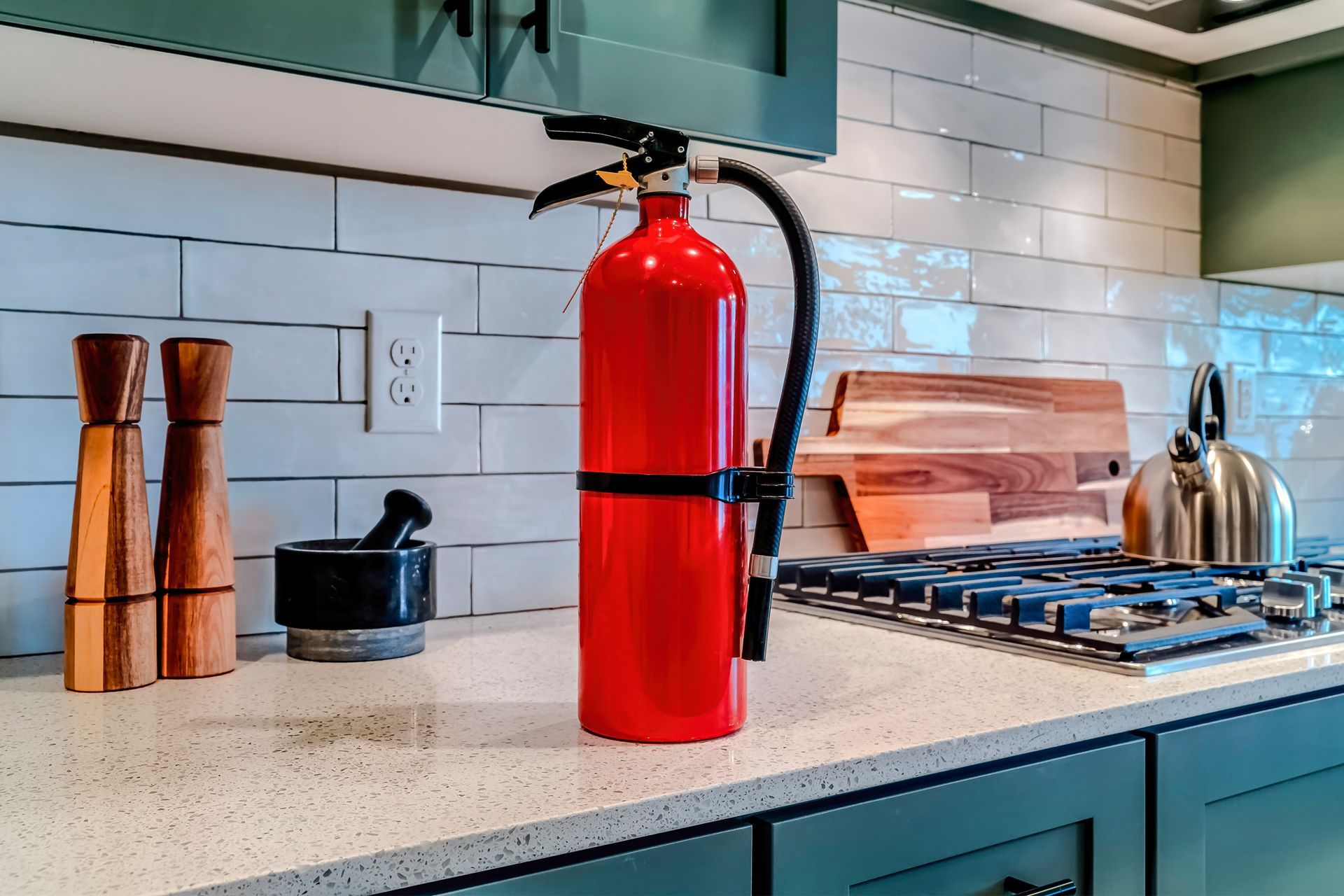 Fire extinguisher on a kitchen countertop, near the stove.