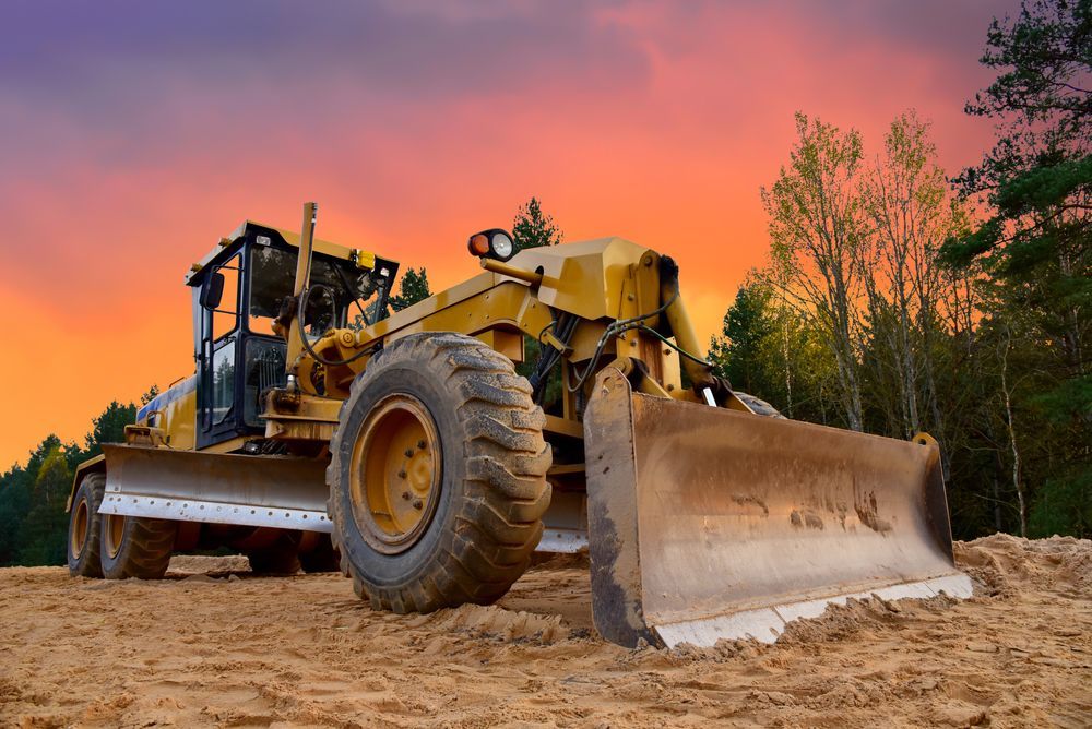 A bulldozer is sitting on top of a dirt field.