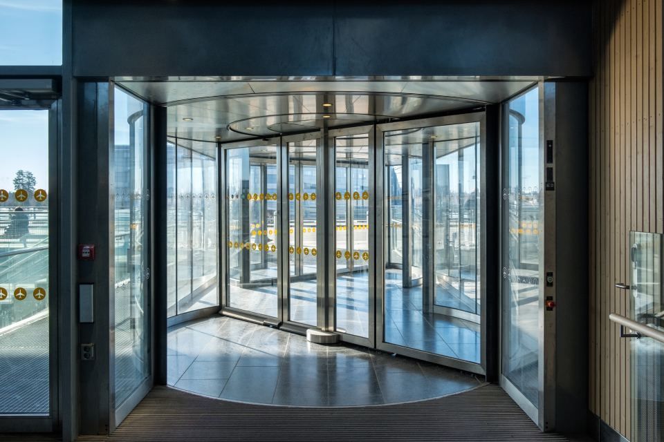 A large glass revolving door in a building.