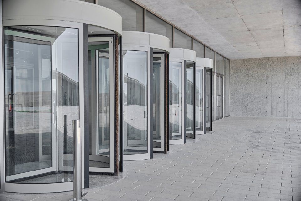 A row of revolving doors in a building with their doors open.