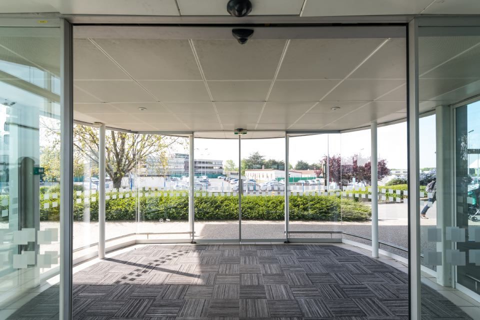 An empty lobby with sliding glass doors and a carpeted floor.