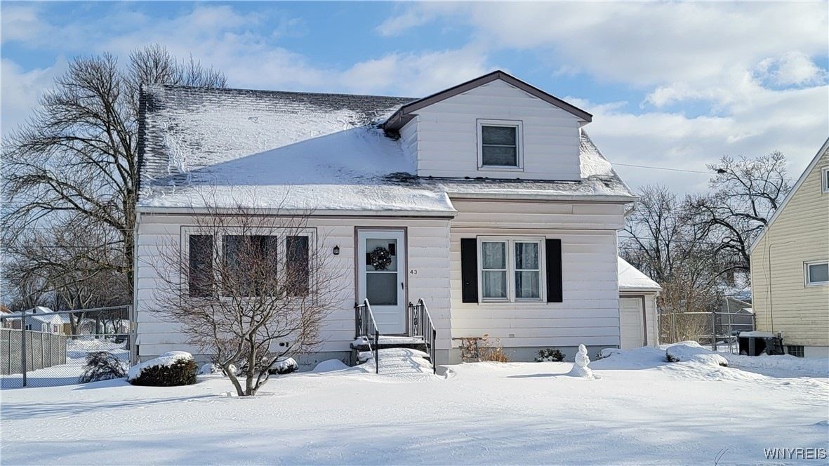 Street view of 43 Alliger Dr, showcasing a cozy home with a snow covered front yard, and detached garage.