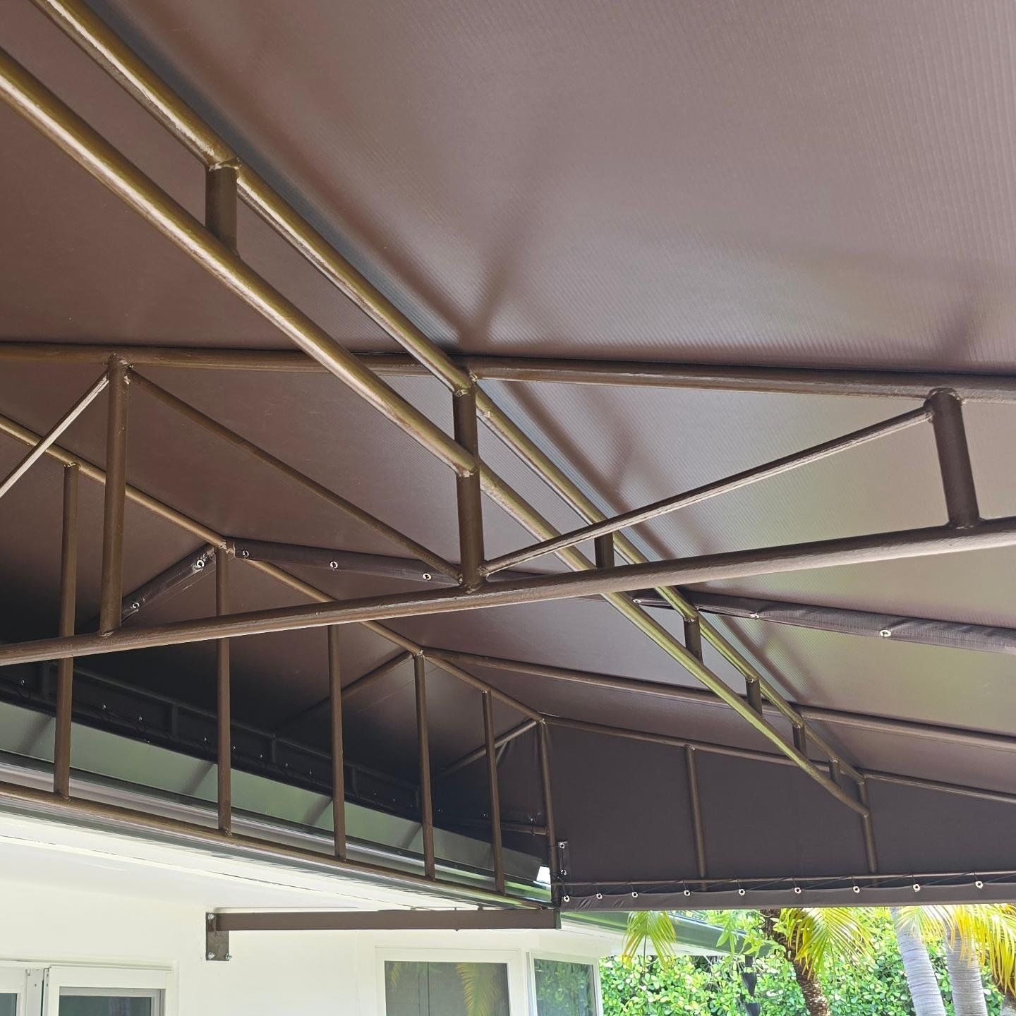 A brown awning is hanging from the roof of a building