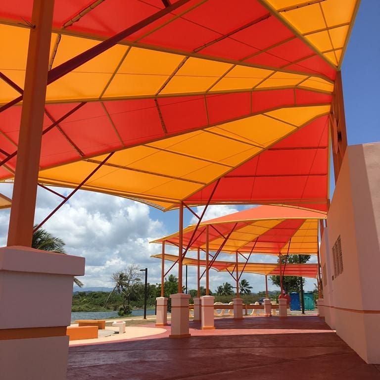 A red and yellow umbrella with a blue sky in the background