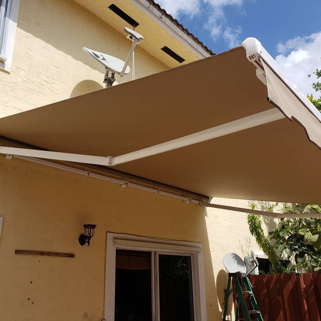 A brown awning is on the side of a house