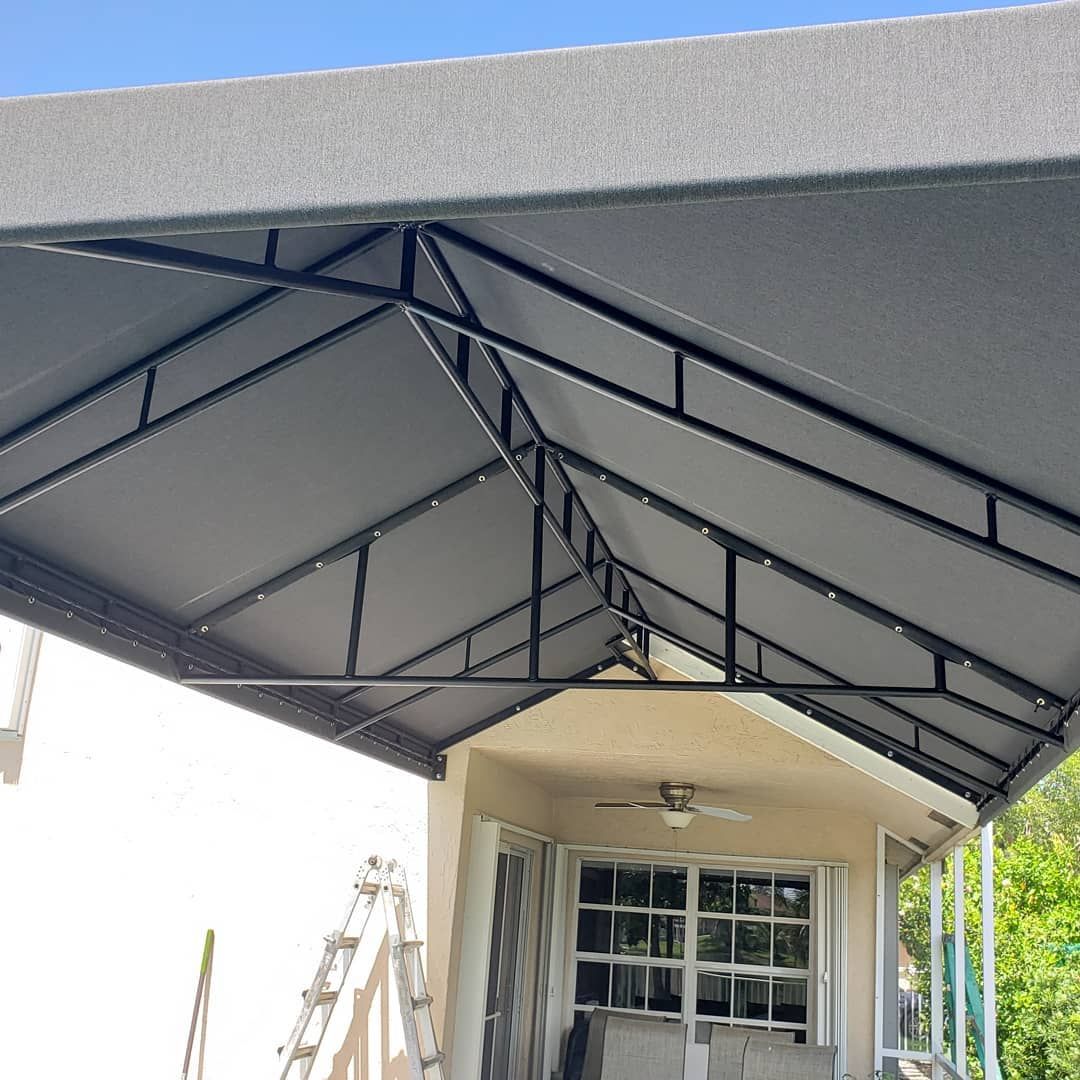 A canopy over a porch with a ladder in the background.