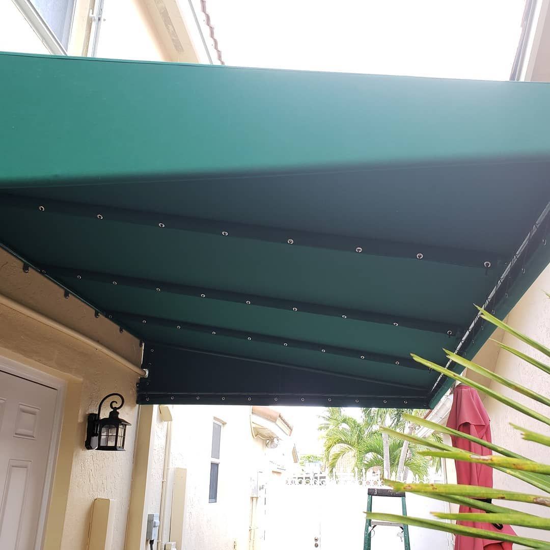 A green awning is covering the entrance to a house.