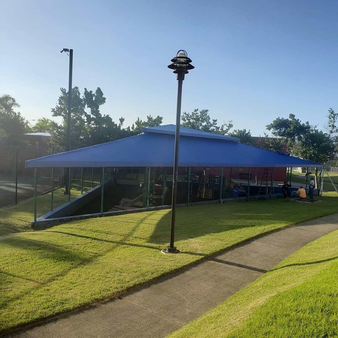 A blue tent is sitting in the middle of a grassy field