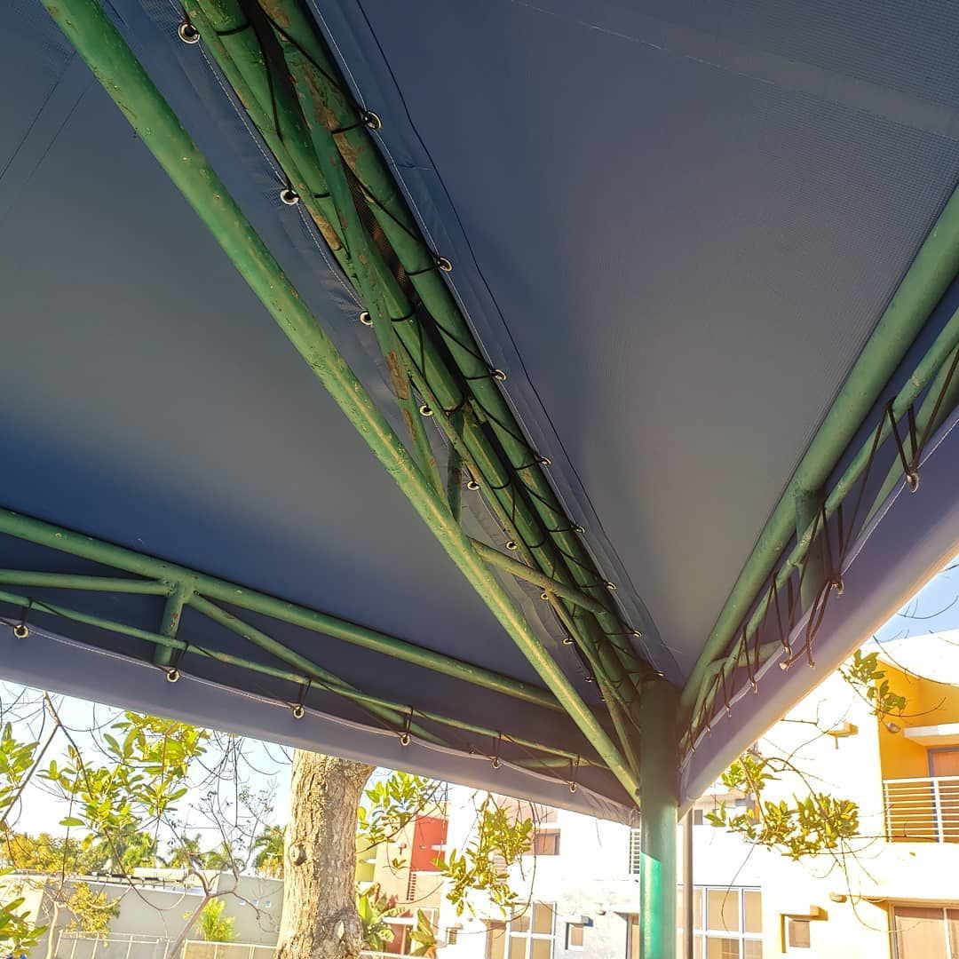 A blue canopy with green pipes hanging from it