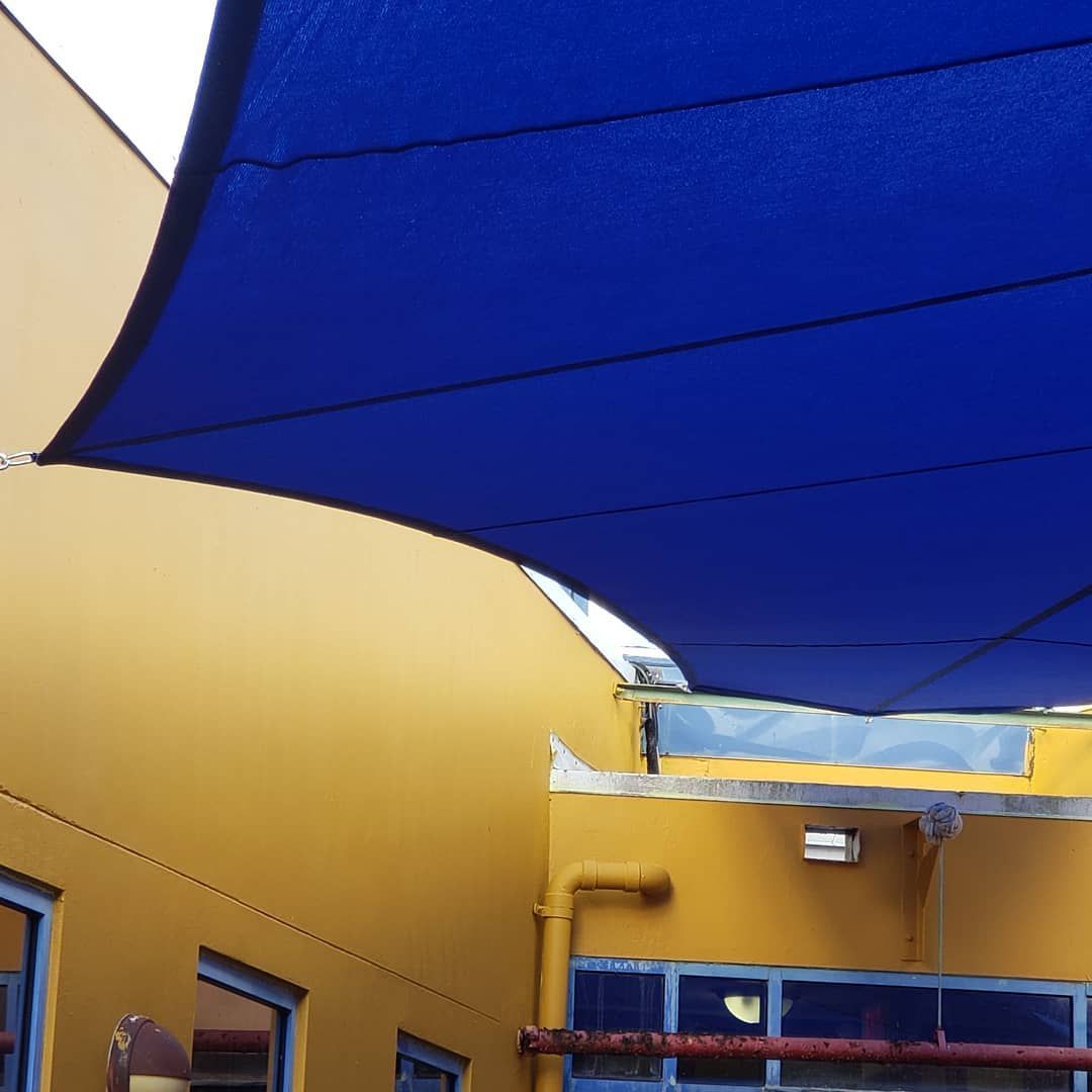 A yellow building with a blue awning over it