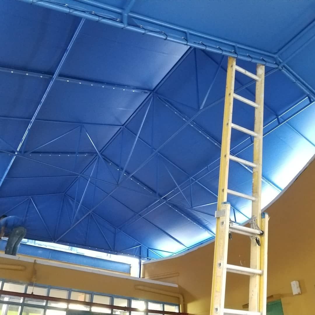 A blue ceiling with a ladder going up to it