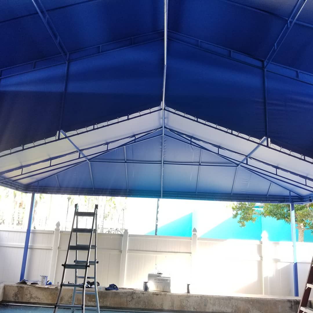 A blue and white tent with a ladder underneath it