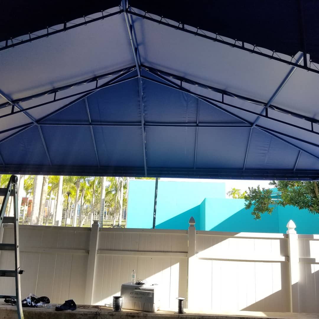A blue canopy with a white fence in the background