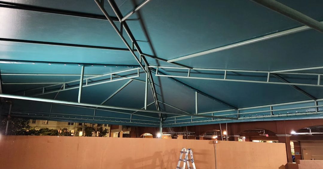 A ladder is sitting under a blue tent.