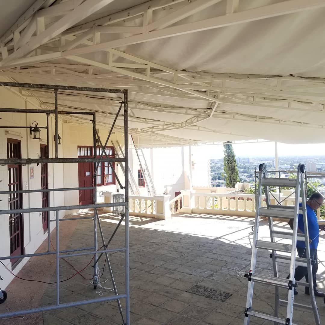 A man standing on a ladder in front of a building