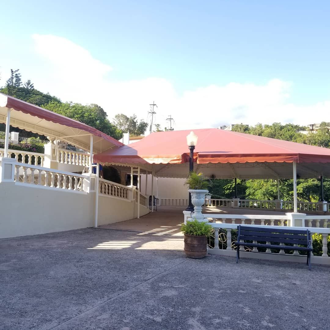 A building with a red roof and a bench in front of it