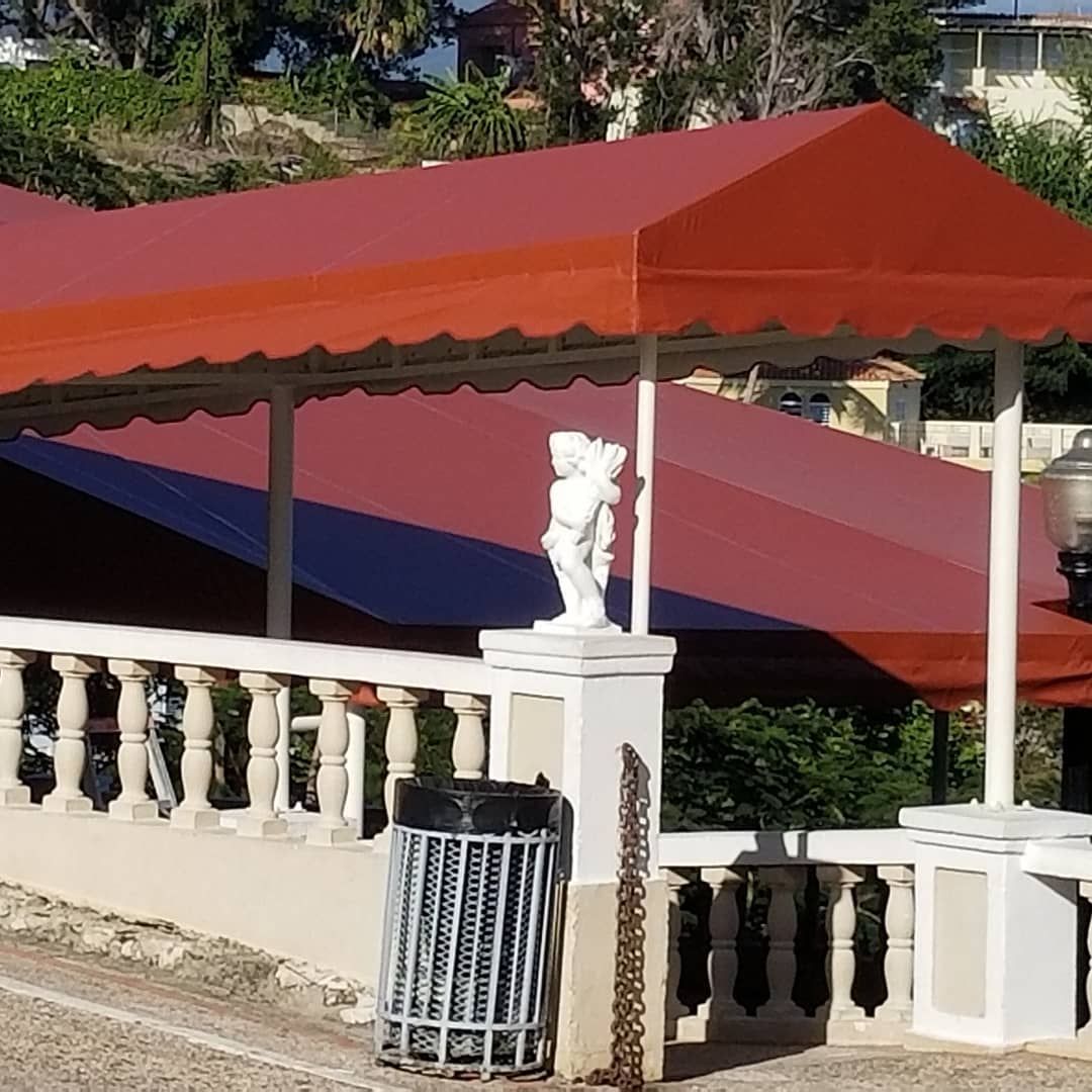 A red awning with a statue on top of it