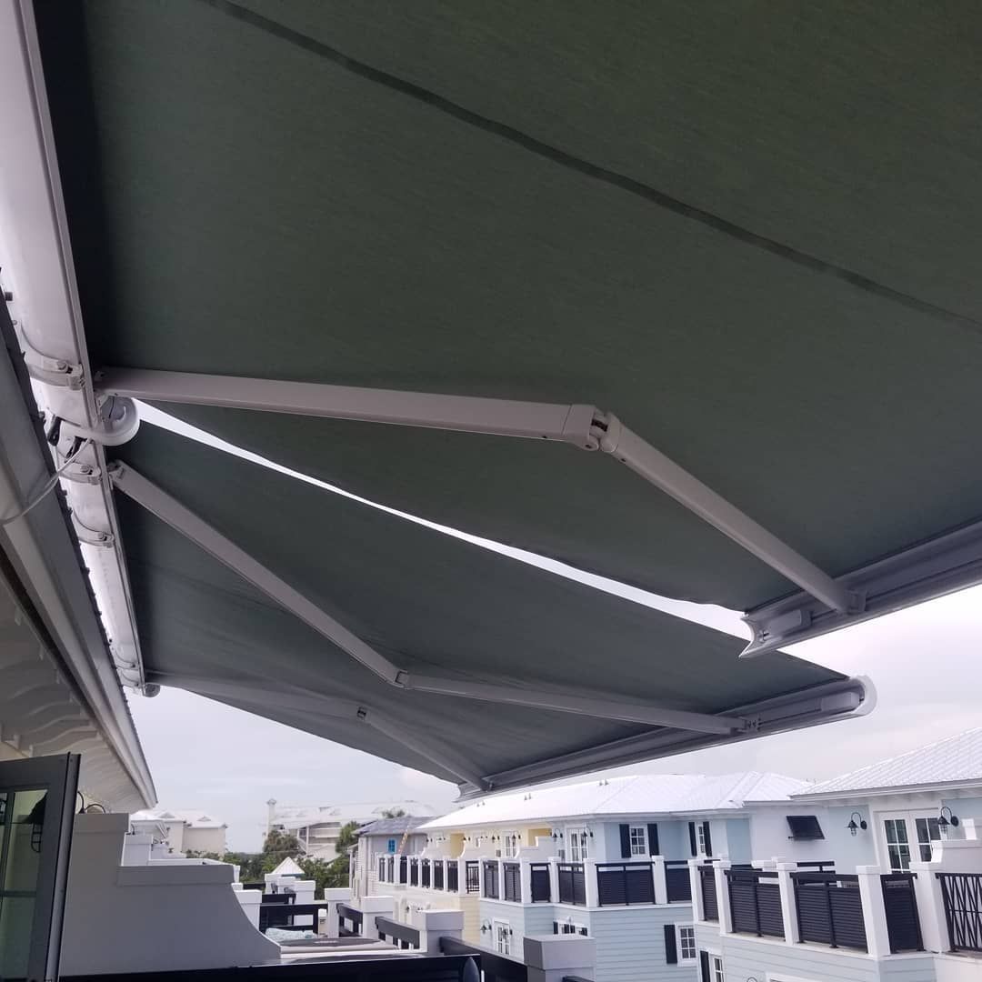 A green awning is hanging from the roof of a building.